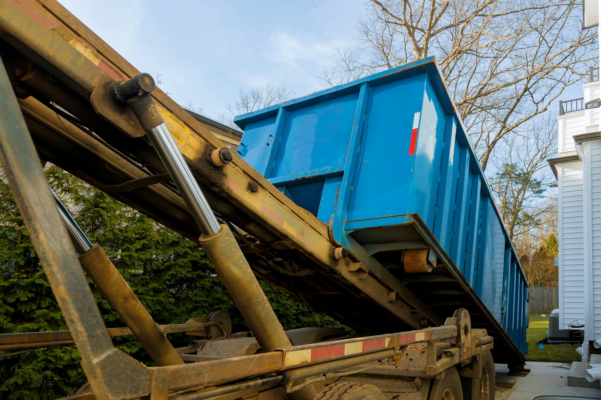 Unloading empty dumpster residential view of new houses being built and construction garbage